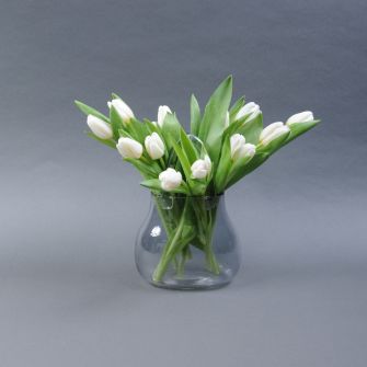 White tulips in a vase in the shape of a handbag
