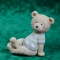 Statuette of a teddy bear in a sweater sitting